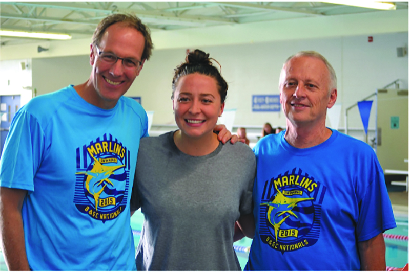Boys and Girls Club Marlins’ coaches Bobby Hackett (Distance Coach), left, and Dennis Munson (Head Coach/Aquatic Director), right, welcome Olympian Ariana Kukors.