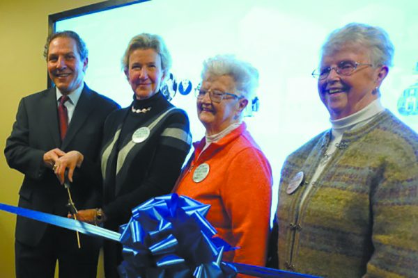 From left: Joel Seligman and Nancy Karch lead a ribbon cutting ceremony with Pat Reilly and Joan Stewart in front of the interactive historical timeline.